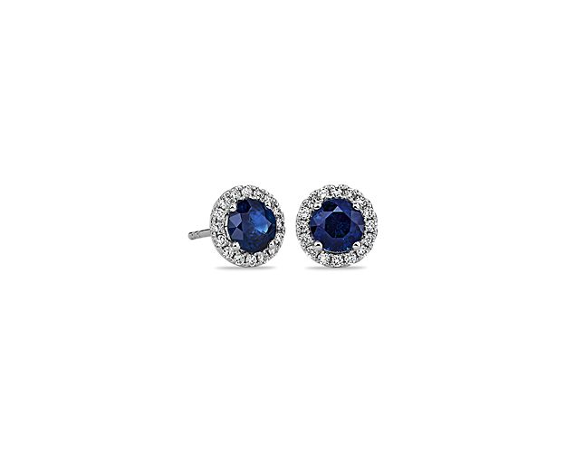 These deep blue sapphire and diamond halo earrings are an excellent choice for someone who wants to add a bit of color to a classic style. Crafted in bright 18k white gold, these gemstone stud earrings feature round sapphires surrounded by sparkling halos of micropavé diamonds. Their petite size makes them a great everyday jewelry option.