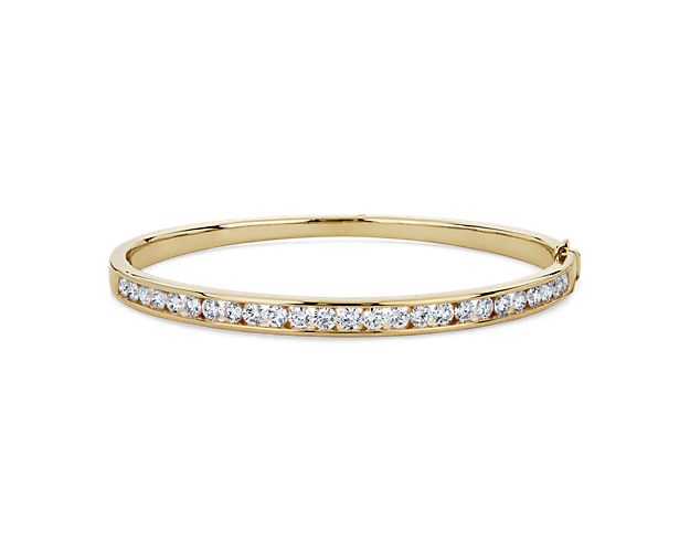 Add gorgeous gleam to your wrist with this round bangle bracelet crafted from warmly lustrous 14k yellow gold. Brilliant lab-grown diamonds encircle the bracelet, adding sparkling luxury.