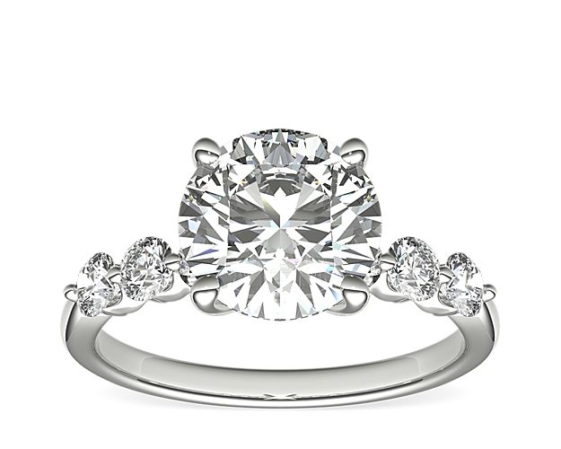 An expression of luxurious elegance, this platinum engagement ring sparkles with excellent-cut sidestones with hearts & arrows complementing the center stone.