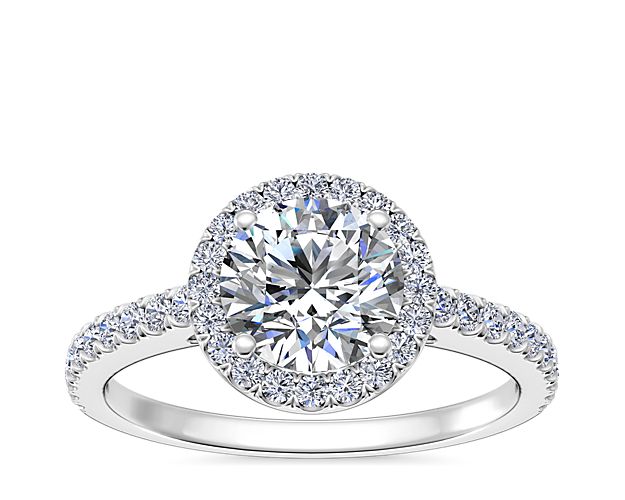 Create a breathtaking moment with this decadent engagement ring, showcasing a diamond laden shank and halo, deftly framed against immaculate 14k white gold.