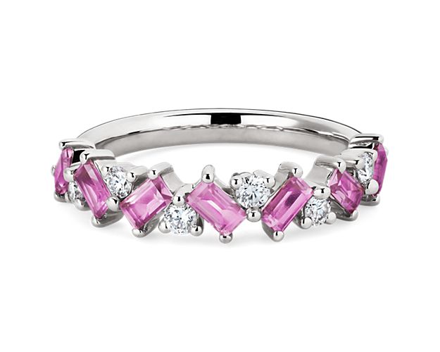 Embrace bold sparkle with this ring featuring emerald-cut pink sapphires along the front of the band, shimmering in symphony with brilliant round-cut diamonds. It is beautifully crafted in gleaming platinum that promises enduring luxurious quality.