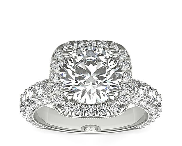 A regal platinum diamond engagement ring showcasing a majestic pavé square halo crown, a gallery covered in milgrain and round diamond detail, and a band with a triple-row of diamonds, including an asscher-cut channel. This setting is custom made to fit your beautiful center stone.