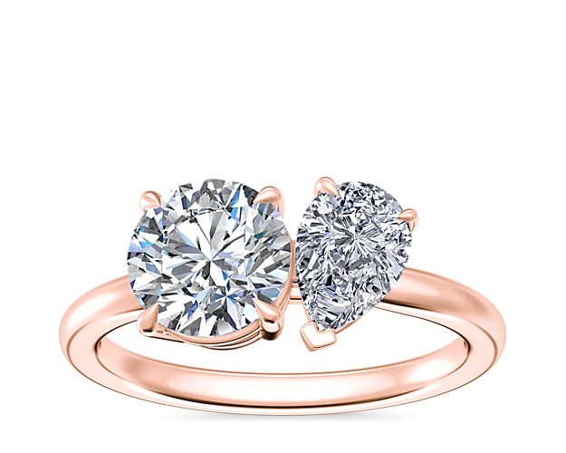 Capture the heart with this stunning engagment ring featuring a two-stone design, with a pear-cut diamond and a chosen round, princess, asscher, emerald-cut, radiant, marquise, or oval diamond for a unique look. The warm gleam of the 14k rose gold gives it a vintage-inspired look.